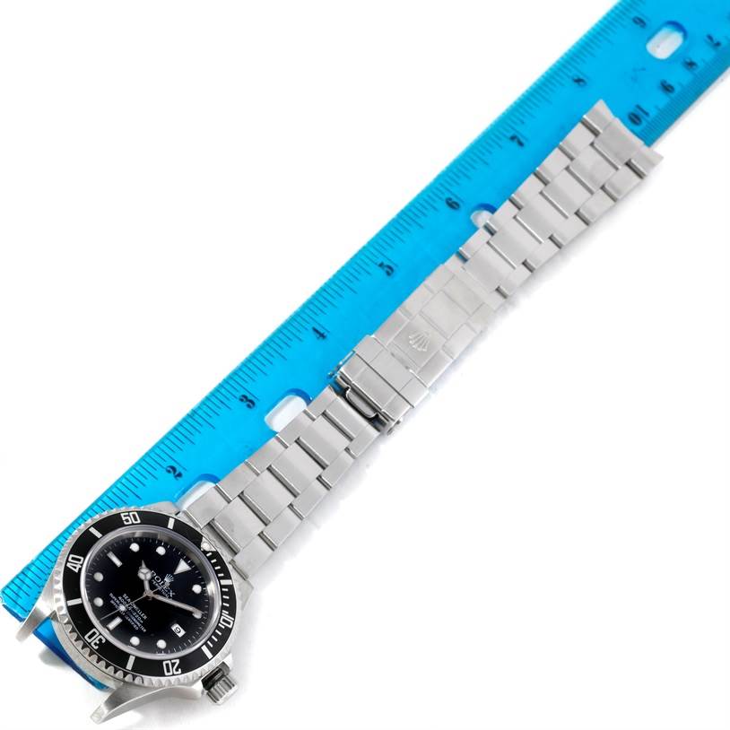 The Rolex Sea-Dweller 16600 Men's Stainless Steel Black Dial 16600 Men's Stainless Steel Black Dial watch is shown from a top-down angle, highlighting its face, bezel, and metal bracelet next to a ruler.