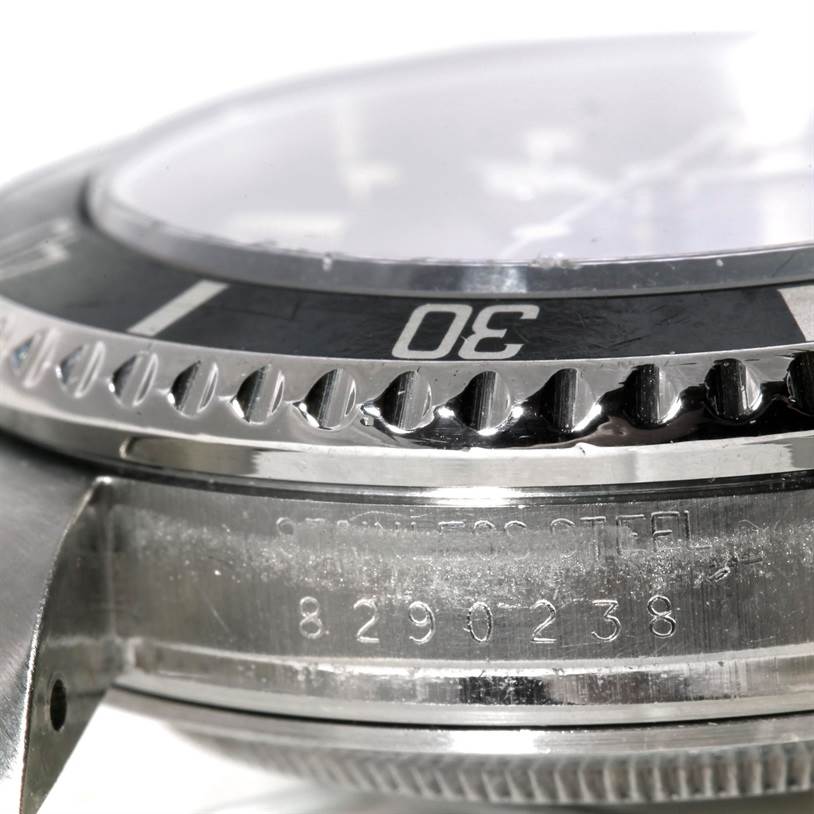 This close-up angle of the Rolex Sea-Dweller 16660 Men's Stainless Steel Black Dial 16660 Men's Stainless Steel Black Dial watch shows the bezel, part of the case, and the serial number engraving.
