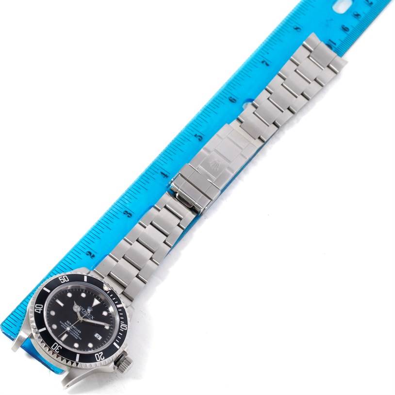 The Rolex Sea-Dweller 16600 Men's Stainless Steel Black Dial 16600 Men's Stainless Steel Black Dial watch is shown fully extended, with its face, bezel, and bracelet visible, alongside a ruler for scale.
