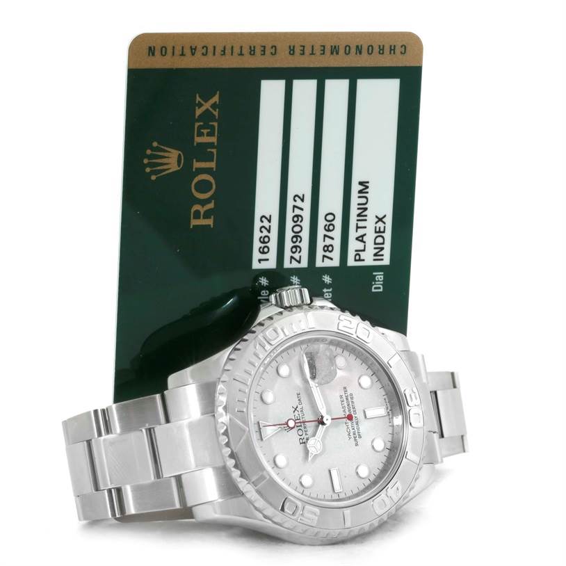The Rolex Yacht-Master 16622 Men's Stainless Steel Silver Dial 16622 Men's Stainless Steel Silver Dial watch is displayed at an angle showing the face, bezel, bracelet, and a certification card behind it.