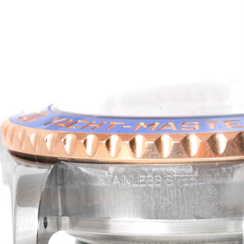 The image shows a close-up side view of a Rolex Yacht-Master 116681 Men's Steel and Gold (two tone) White Dial 116681 Men's Steel and Gold (two tone) White Dial bezel and case with "STAINLESS STEEL" engraved.