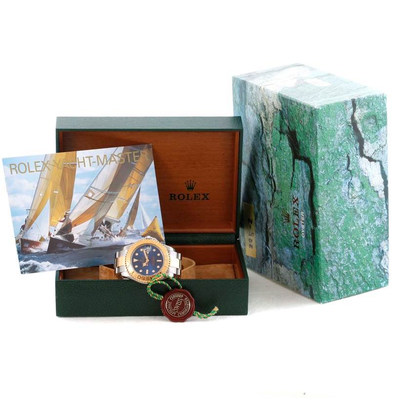 The Rolex Yacht-Master 68623 Men's Stainless Steel Blue Dial 68623 Men's Stainless Steel Blue Dial watch is shown in its open box with a manual and outer packaging visible.