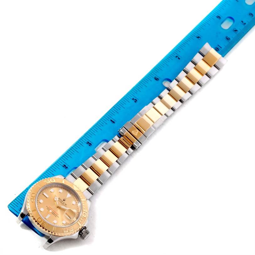 The image shows a top-down view of a Rolex Yacht-Master 16623 Men's Stainless Steel Champagne Dial 16623 Men's Stainless Steel Champagne Dial watch with a two-tone bracelet next to a blue ruler.