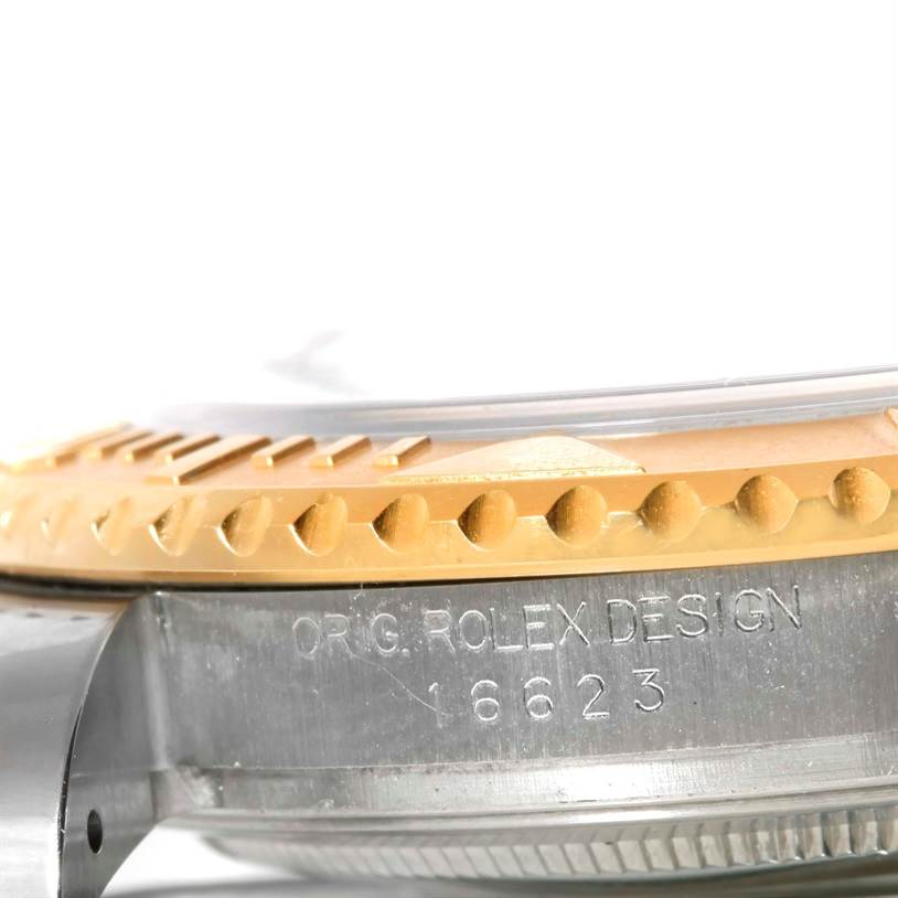 The photo shows a close-up side view of the Rolex Yacht-Master 16623 Men's Stainless Steel White Dial 16623 Men's Stainless Steel White Dial 16623 model's bezel and case, highlighting the engraved text.