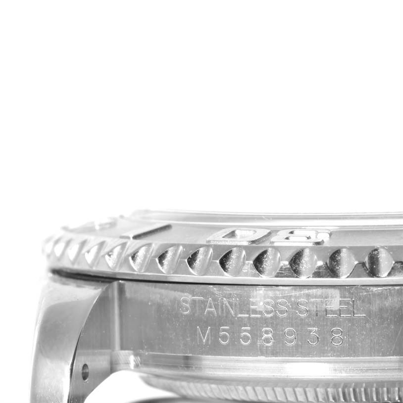 The image shows a side angle of a Rolex Yacht-Master 16622 Men's Stainless Steel Silver Dial 16622 Men's Stainless Steel Silver Dial with focus on its bezel and case with engraved details.