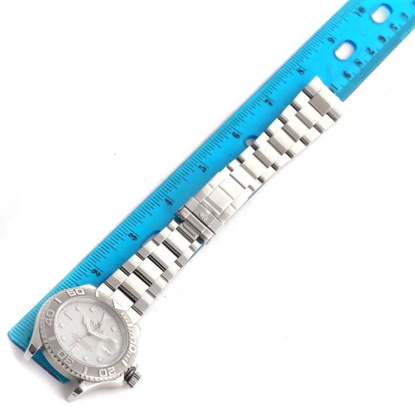 The image shows a Rolex Yacht-Master 16622 Men's Stainless Steel Silver Dial 16622 Men's Stainless Steel Silver Dial watch laid flat beside a ruler, displaying the watch face, bezel, crown, and bracelet.