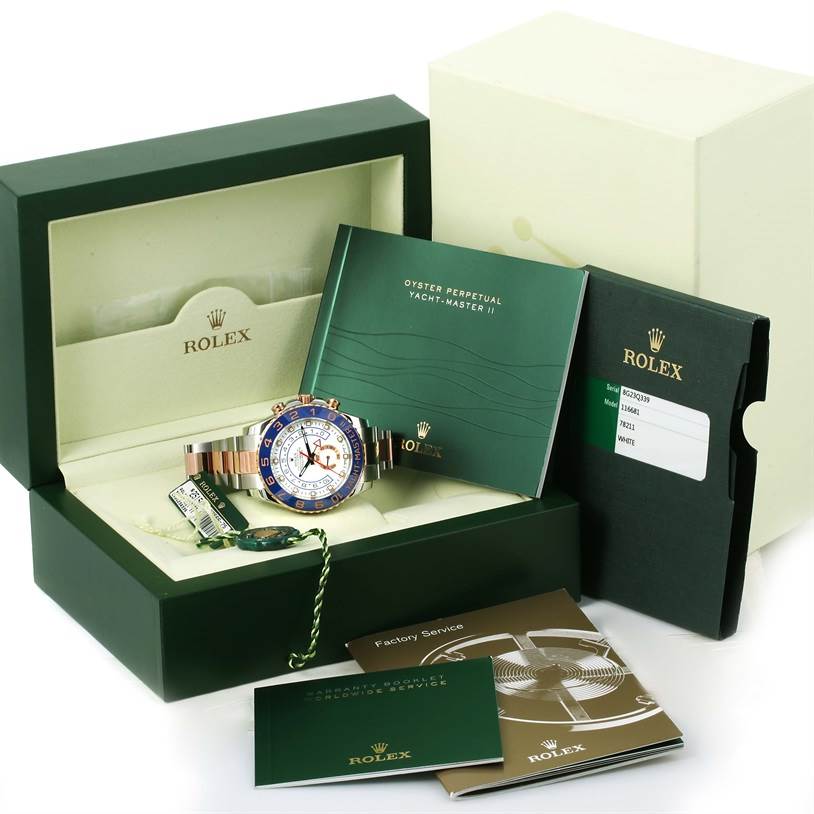 The image shows a Rolex Yacht-Master 116681 Men's Steel and Gold (two tone) White Dial 116681 Men's Steel and Gold (two tone) White Dial II watch with its box, manuals, tags, and warranty card displayed at an angled view.