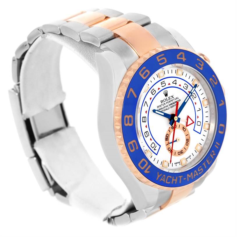 The Rolex Yacht-Master 116681 Men's Steel and Gold (two tone) White Dial 116681 Men's Steel and Gold (two tone) White Dial watch is shown at an oblique angle, displaying its blue bezel, white dial, and two-tone metal bracelet.