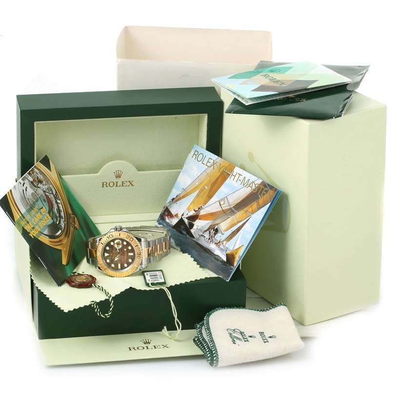 The Rolex Yacht-Master 16623 Men's Stainless Steel Mother of Pearl Dial 16623 Men's Stainless Steel Mother of Pearl Dial watch is displayed from the front in its box, alongside booklets, a tag, and a cleaning cloth.