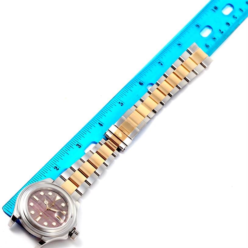 This top-down image shows the Yacht-Master model by Rolex, focusing on its face and metal strap with a ruler for measurement.