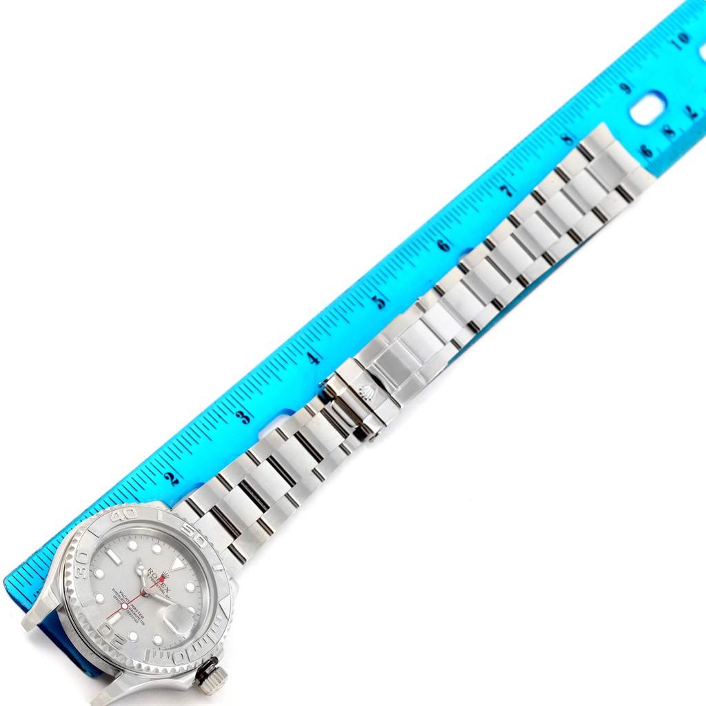 The image shows a top-down view of a Rolex Yacht-Master 16622 Men's Stainless Steel Silver Dial 16622 Men's Stainless Steel Silver Dial watch, including the face and bracelet, aligned with a blue ruler.