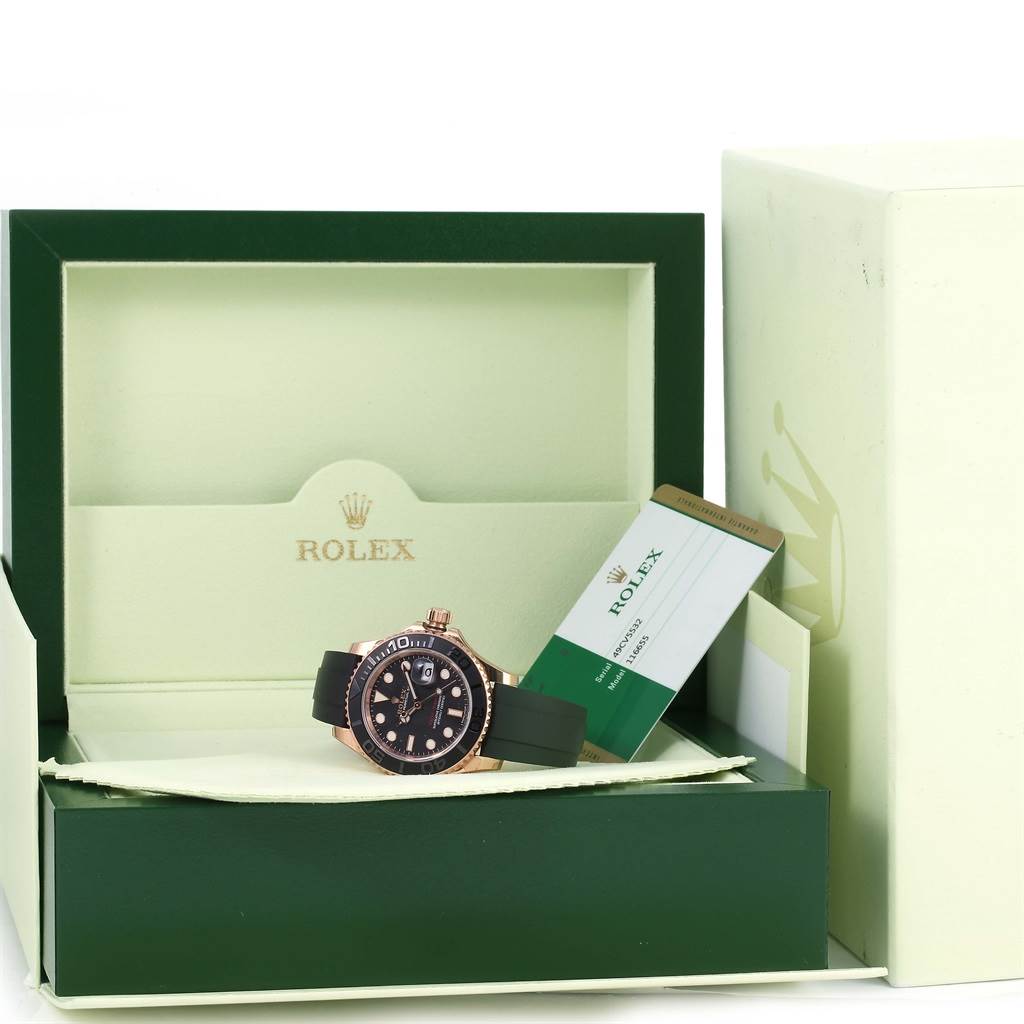 The Rolex Yacht-Master 116655 Men's Rose Gold Black Dial 116655 Men's Rose Gold Black Dial watch is shown from the front, inside its open box with accompanying certification cards.
