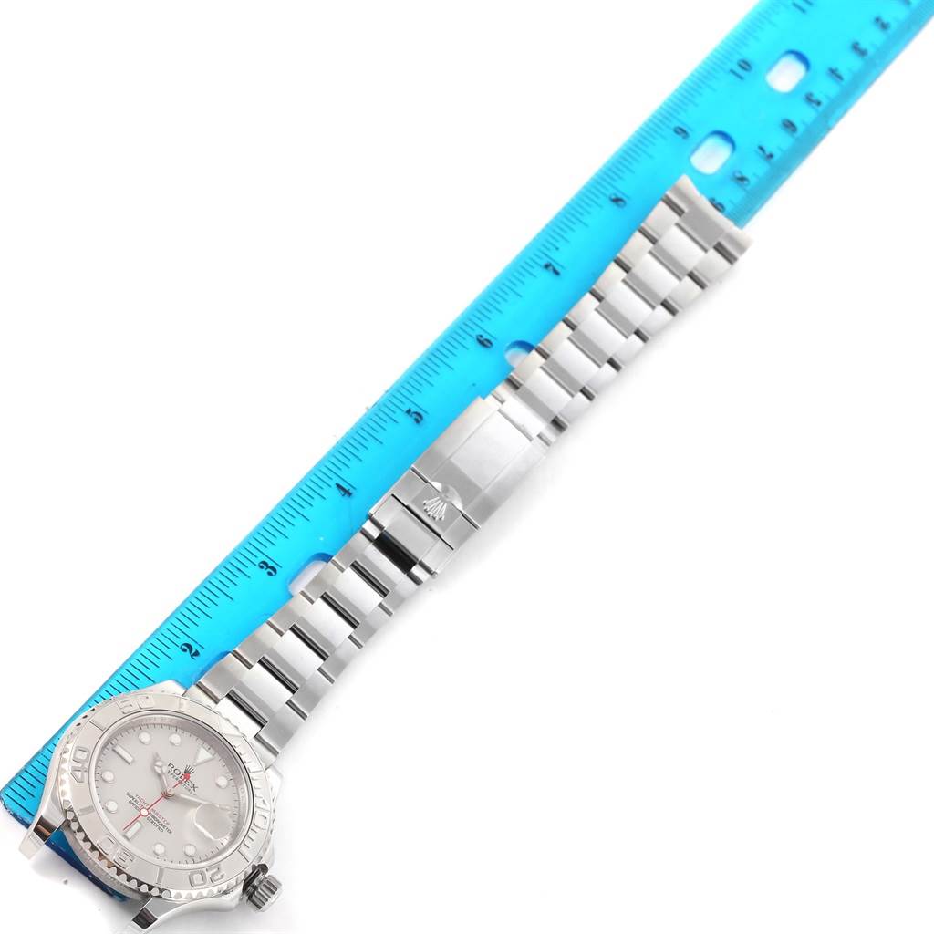 The image shows a top-down view of a Rolex Yacht-Master 116622 Men's Stainless Steel Silver Dial 116622 Men's Stainless Steel Silver Dial watch alongside a blue ruler, highlighting the bracelet and clasp.