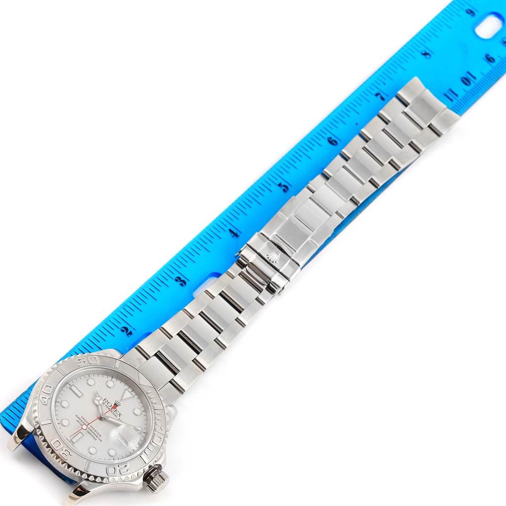 The Rolex Yacht-Master 16622 Men's Stainless Steel Silver Dial 16622 Men's Stainless Steel Silver Dial watch is shown from a top-down angle, displaying the face and band next to a blue ruler for scale.