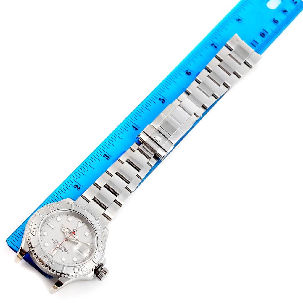 The image shows a Rolex Yacht-Master 16622 Men's Stainless Steel Silver Dial 16622 Men's Stainless Steel Silver Dial watch laid flat next to a blue ruler, showcasing its bracelet and case.