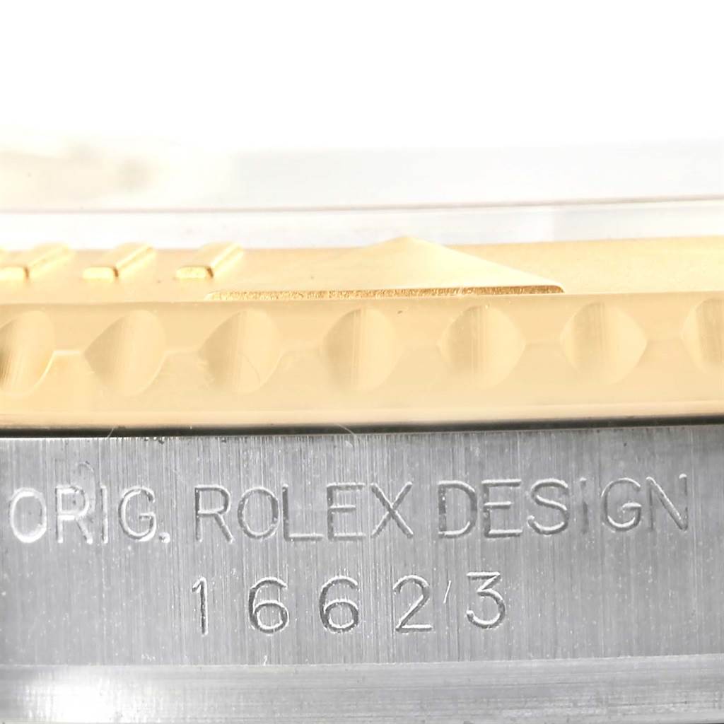 The image shows a close-up angle of the engraved bezel and case side of a Rolex Yacht-Master 16623 Men's Stainless Steel Champagne Dial 16623 Men's Stainless Steel Champagne Dial watch.