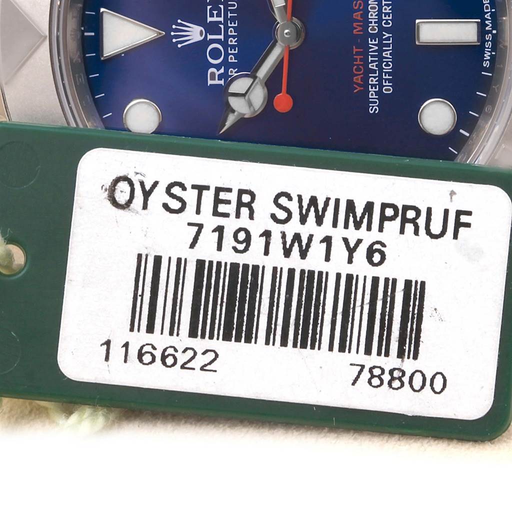 The image shows a close-up of a Rolex Yacht-Master 116622 Men's Stainless Steel Blue Dial 116622 Men's Stainless Steel Blue Dial watch dial and an Oyster Swimpruf tag.