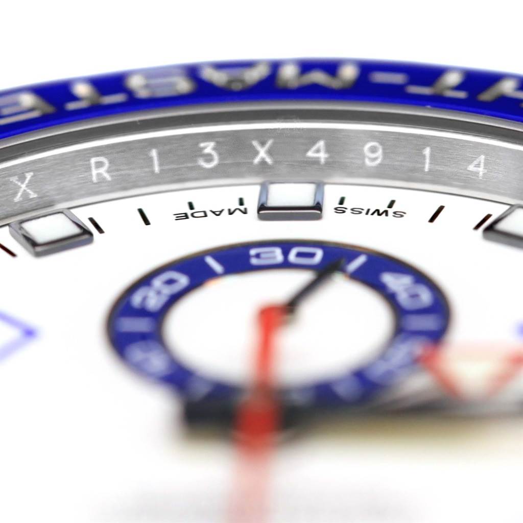 This close-up image of a Rolex Yacht-Master 116680 Men's Stainless Steel White Dial 116680 Men's Stainless Steel White Dial highlights its blue bezel, part of the dial, numerals, and hands.