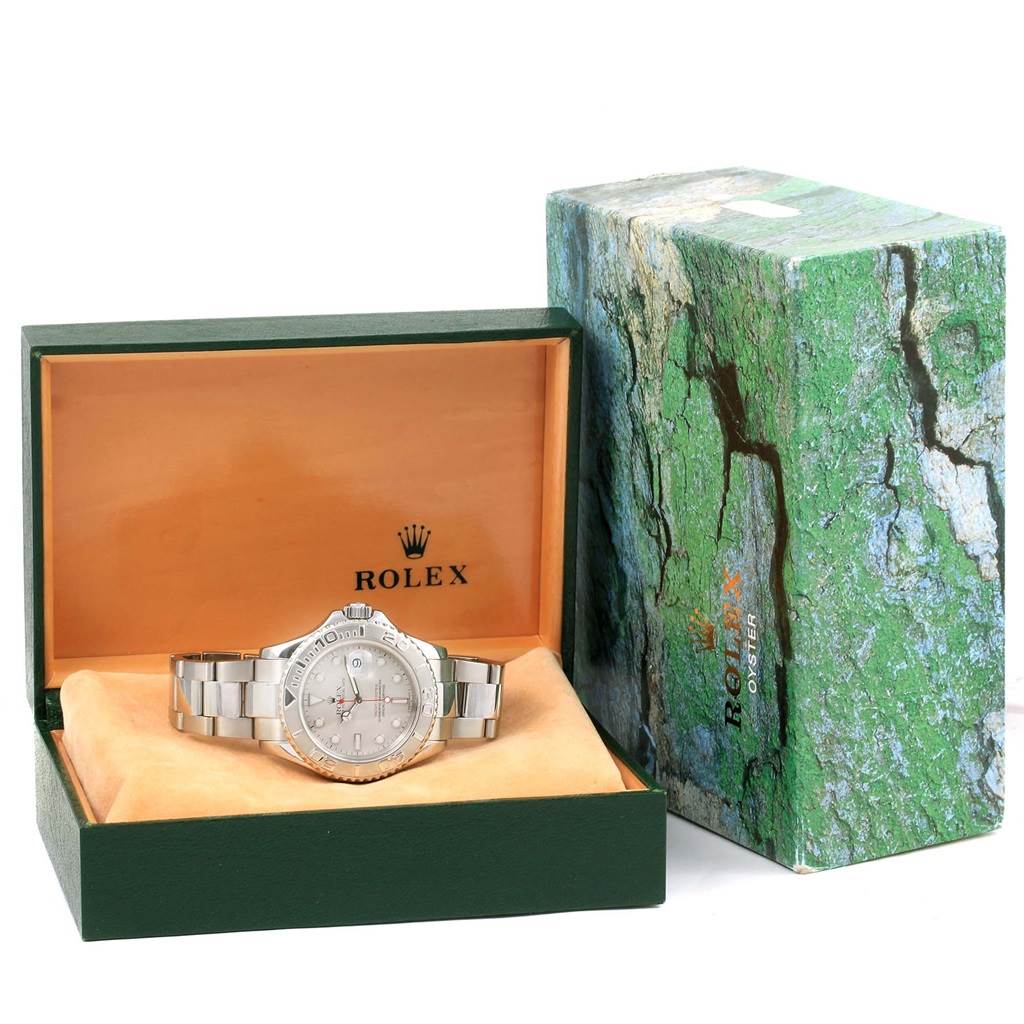 The Rolex Yacht-Master 16622 Men's Stainless Steel Silver Dial 16622 Men's Stainless Steel Silver Dial watch is shown in its box, angled to display the dial, bezel, and bracelet next to the outer green packaging.