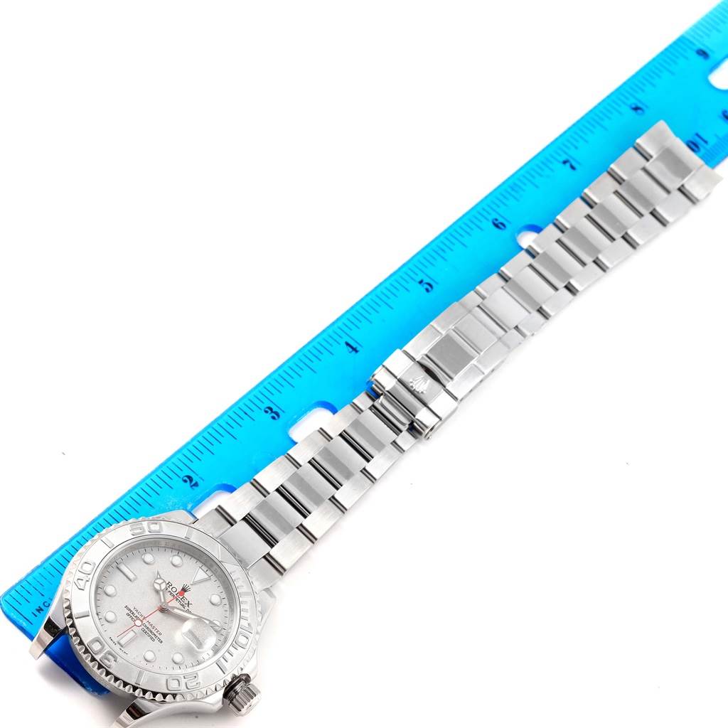 This image shows a top-down view of a Rolex Yacht-Master 16622 Men's Stainless Steel Silver Dial 16622 Men's Stainless Steel Silver Dial watch placed next to a blue ruler for scale.