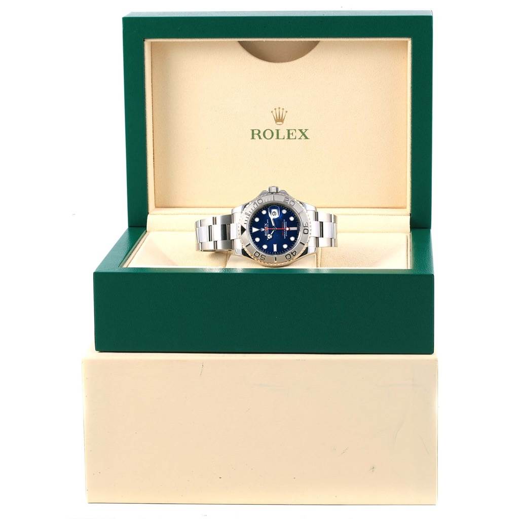This image shows a Rolex Yacht-Master 116622 Men's Stainless Steel Blue Dial 116622 Men's Stainless Steel Blue Dial watch positioned front-on within its green and cream presentation box.
