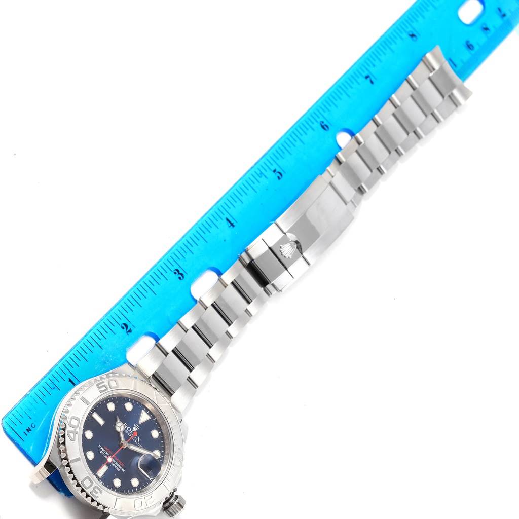 The image shows a side angle of a Rolex Yacht-Master 116622 Men's Stainless Steel Blue Dial 116622 Men's Stainless Steel Blue Dial watch, including the face, bezel, and metal bracelet, with a ruler for scale.