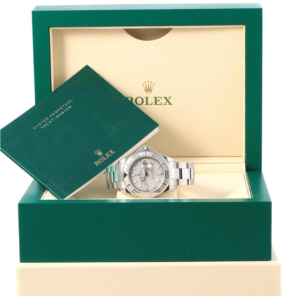 The image shows a Rolex Yacht-Master 16622 Men's Stainless Steel Silver Dial 16622 Men's Stainless Steel Silver Dial watch in an open green and cream-colored box with a manual propped inside it.