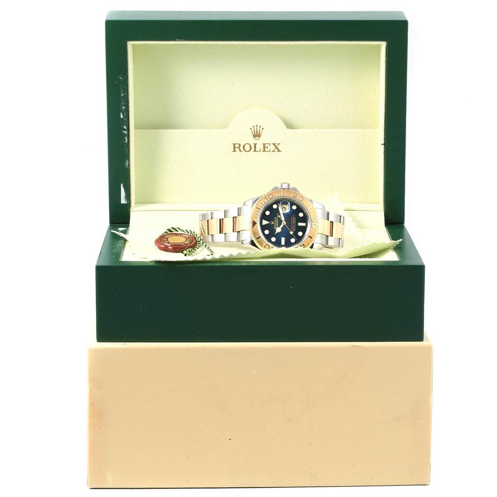 The Yacht-Master Rolex watch is shown in its open green and cream box, with the watch face and bracelet visible.