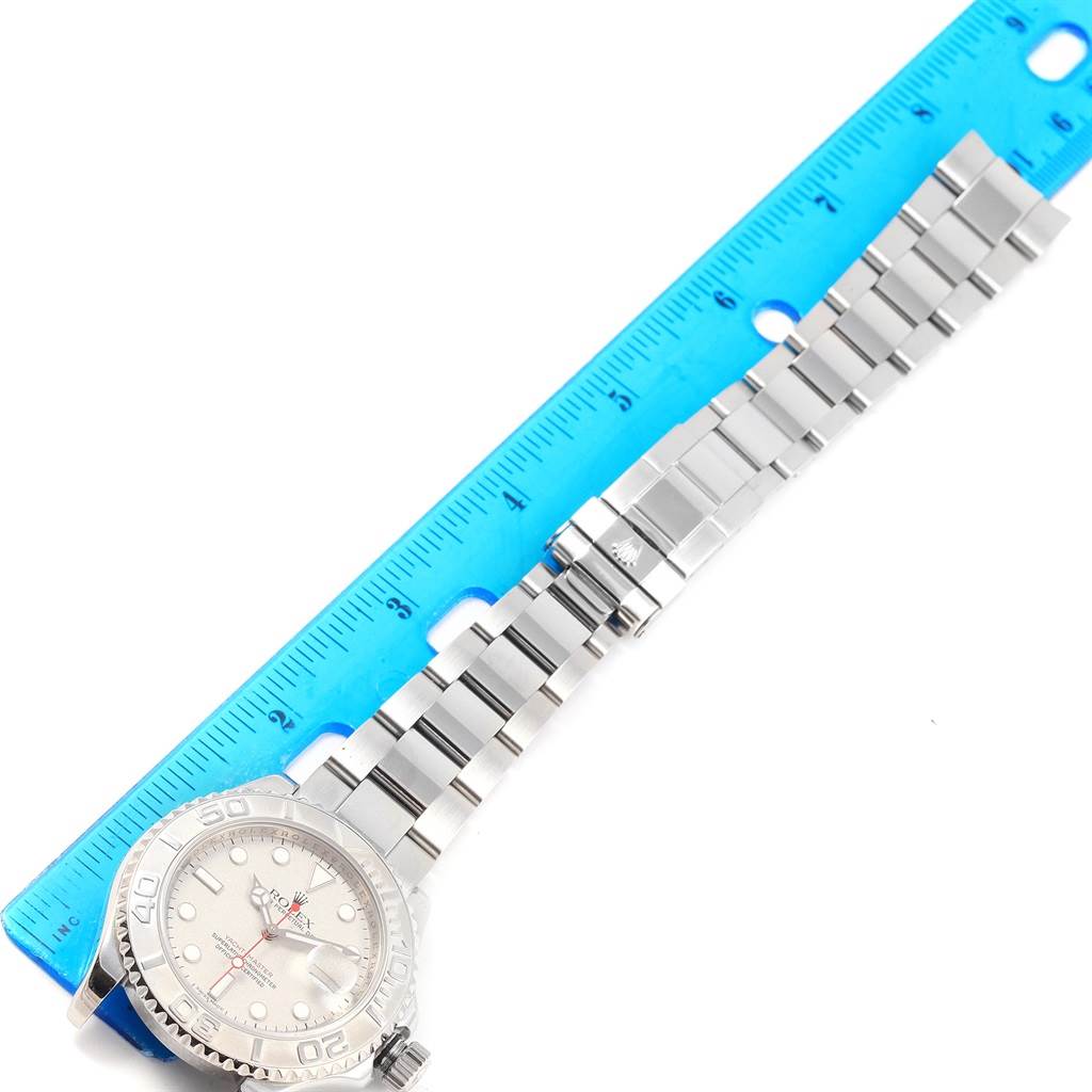 This image shows a close-up of the Rolex Yacht-Master 16622 Men's Stainless Steel Silver Dial 16622 Men's Stainless Steel Silver Dial watch laid next to a ruler, displaying its face and steel bracelet.