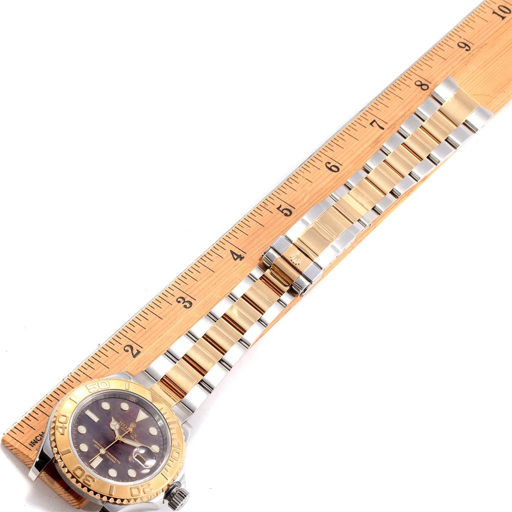The Yacht-Master Rolex watch is shown from the front with its strap aligned next to a ruler for scale.