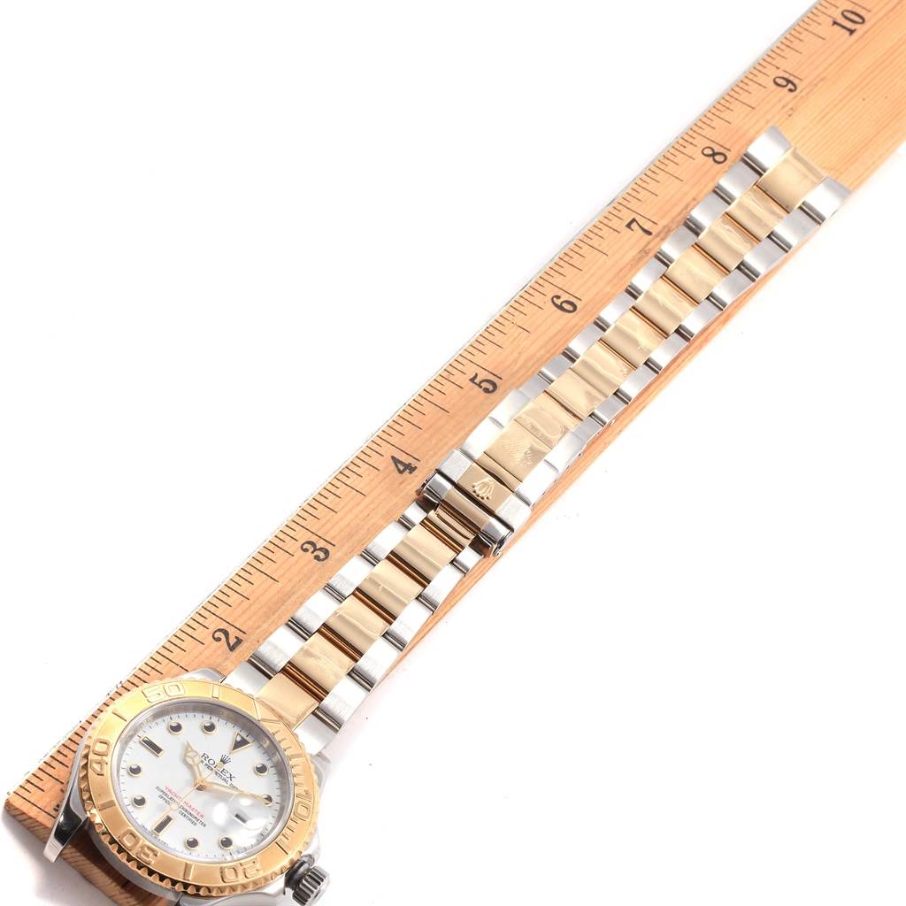 The Rolex Yacht-Master 16623 Men's Stainless Steel White Dial 16623 Men's Stainless Steel White Dial watch is shown from top-down, displaying the face, bezel, and two-tone bracelet placed beside a ruler.