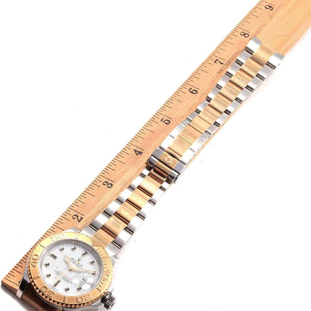 This top-down image shows the face and bracelet of a Rolex Yacht-Master 16623 Men's Stainless Steel White Dial 16623 Men's Stainless Steel White Dial watch alongside a ruler for size reference.