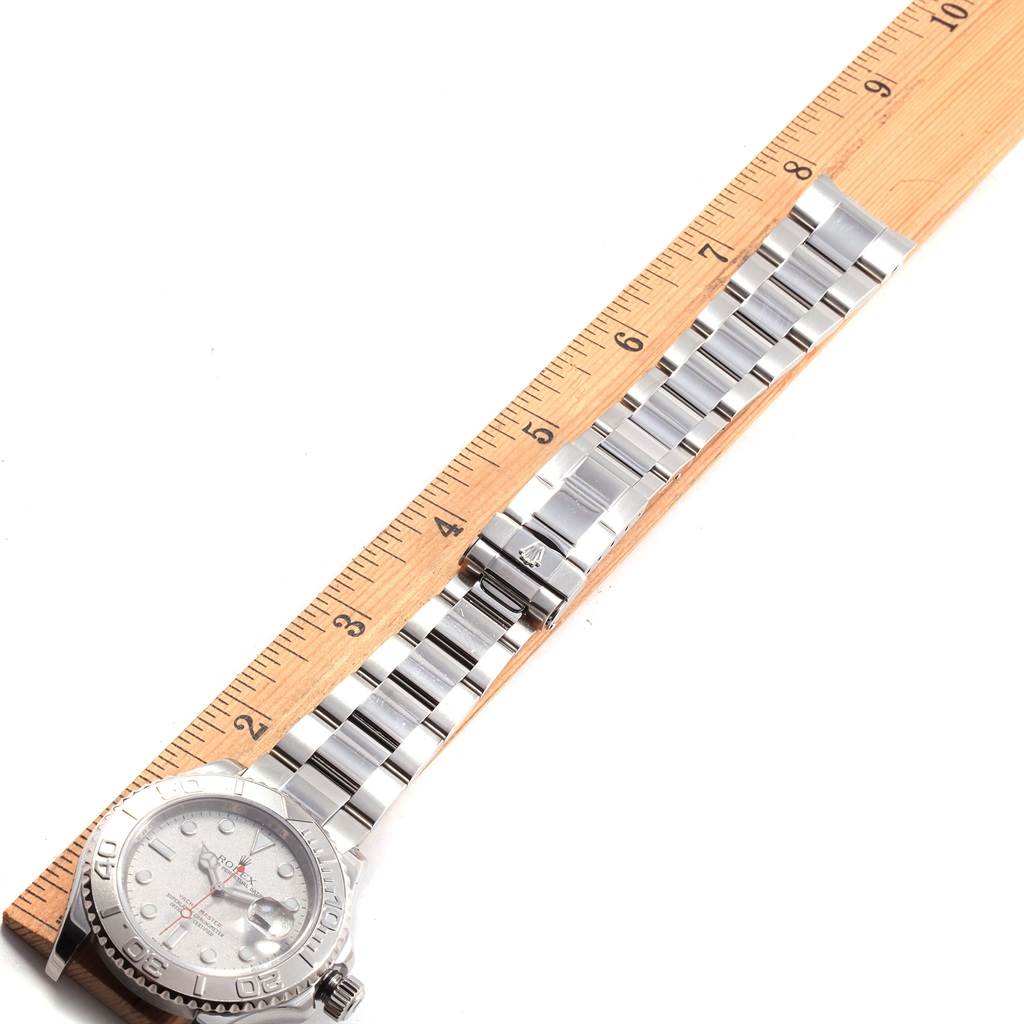 The image shows a side view of the Rolex Yacht-Master 16622 Men's Stainless Steel Silver Dial 16622 Men's Stainless Steel Silver Dial watch with its full bracelet length laid next to a wooden ruler for measurement.