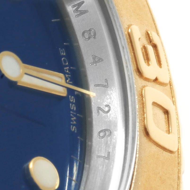 The close-up image of the Rolex Yacht-Master 16623 Men's Stainless Steel Blue Dial 16623 Men's Stainless Steel Blue Dial watch shows part of the blue dial, gold hand, and numbering on the bezel.
