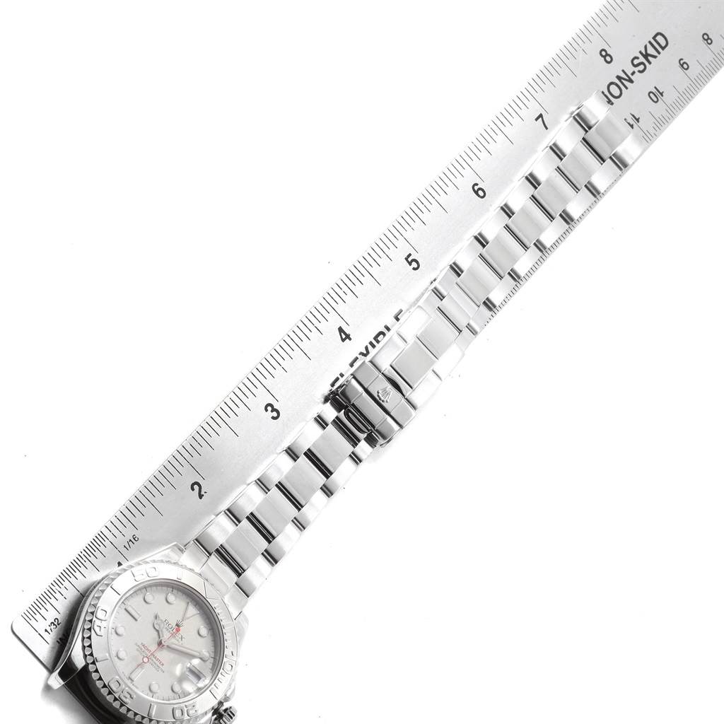 The image shows the Rolex Yacht-Master 168622 Men's Stainless Steel Silver Dial 168622 Men's Stainless Steel Silver Dial watch placed beneath a ruler, highlighting its bracelet and clasp.