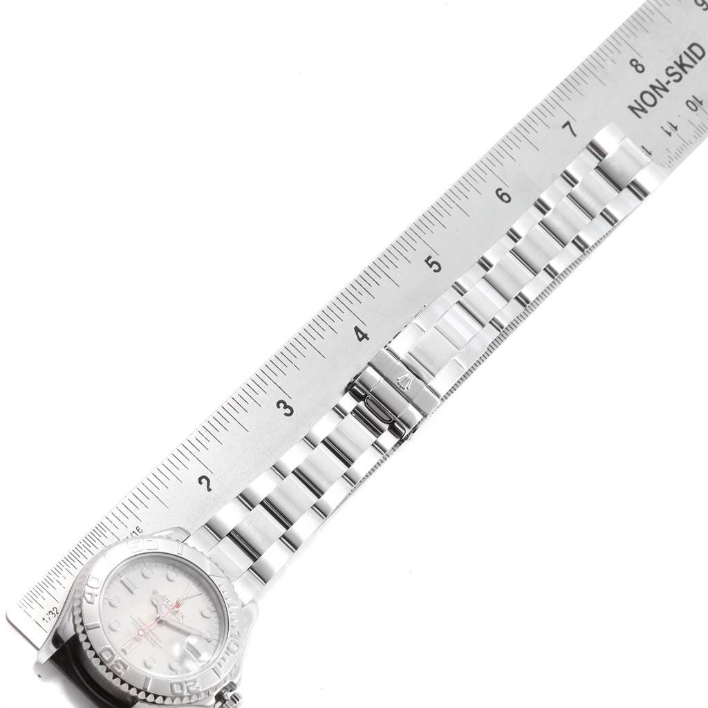 The Rolex Yacht-Master 168622 Men's Stainless Steel Silver Dial 168622 Men's Stainless Steel Silver Dial watch is shown from an overhead angle, emphasizing its silver bracelet and partially visible face next to a ruler.