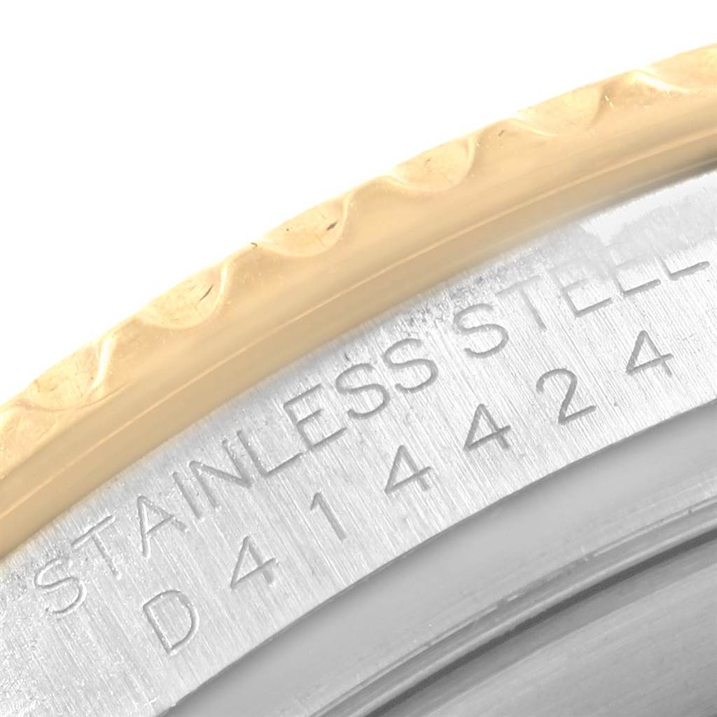 This close-up of the Rolex Yacht-Master 16623 Men's Stainless Steel White Dial 16623 Men's Stainless Steel White Dial model shows part of the bezel, stainless steel case, and some engraved serial numbers.