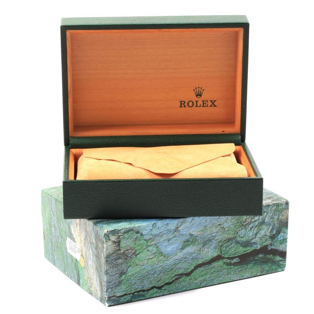 This image shows an open green Rolex box with the lid bearing the Rolex logo, and a Yacht-Master watch covered in a cloth inside.