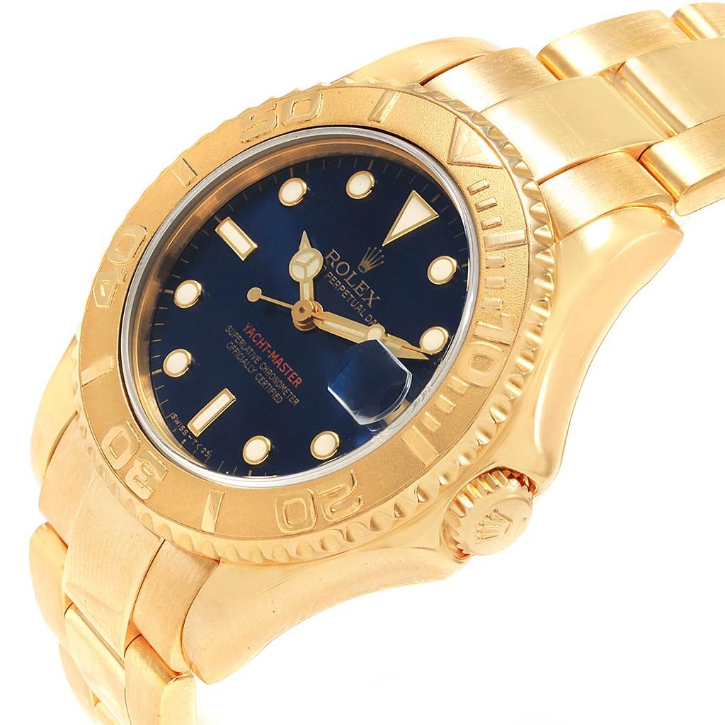 The image shows a close-up angle of a Rolex Yacht-Master 68628 Yellow Gold Blue Dial 68628 Yellow Gold Blue Dial watch, highlighting its gold case, bezel, bracelet, and blue dial.