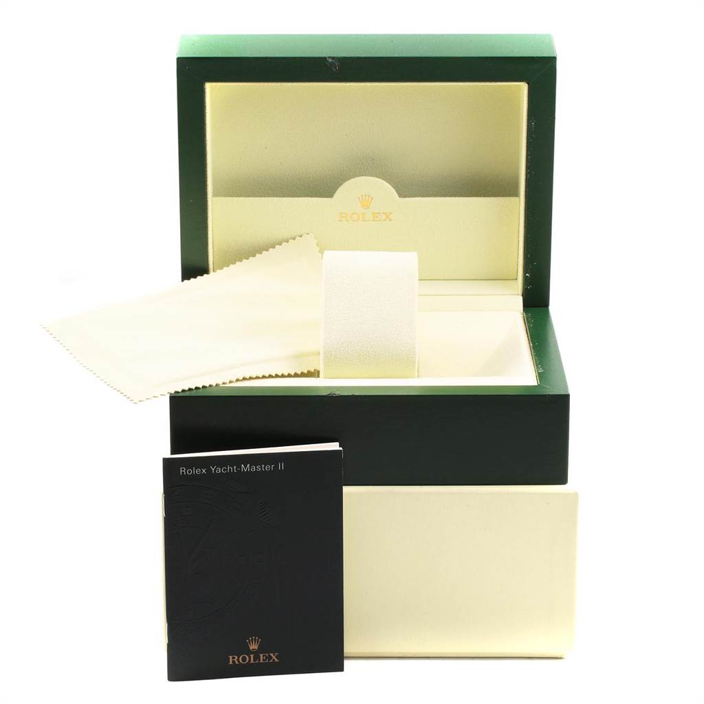 The image shows an open Rolex Yacht-Master 116689 Men's White Gold White Dial 116689 Men's White Gold White Dial box with a cleaning cloth and a booklet in front.