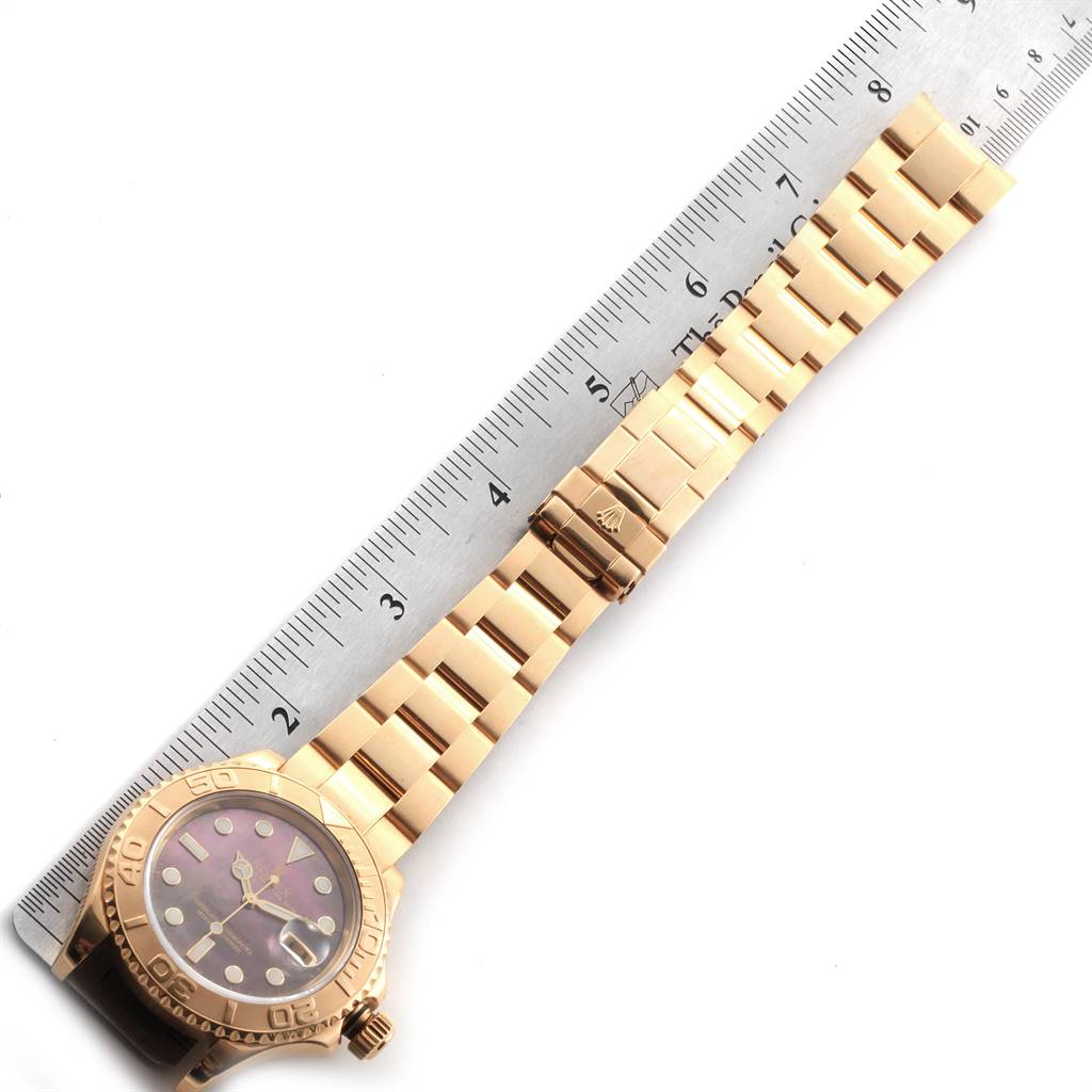 The image shows a Rolex Yacht-Master 16628 Men's Yellow Gold Mother of Pearl Dial 16628 Men's Yellow Gold Mother of Pearl Dial watch laid flat, displaying the face, bezel, and bracelet next to a ruler for scale.