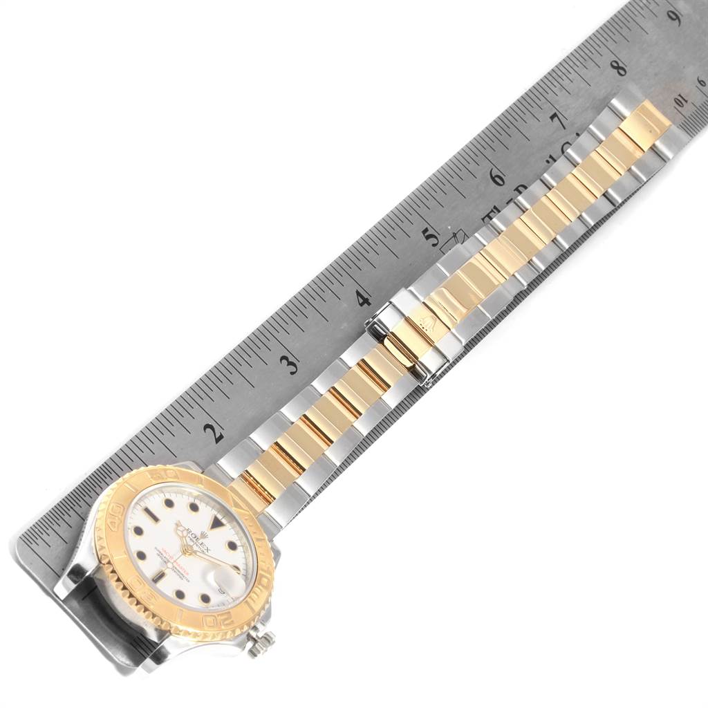 This image shows a Rolex Yacht-Master 168623 Men
s Steel and Gold (two tone) White Dial 168623 Men
s Steel and Gold (two tone) White Dial watch laid flat with the wristband extended alongside a ruler.