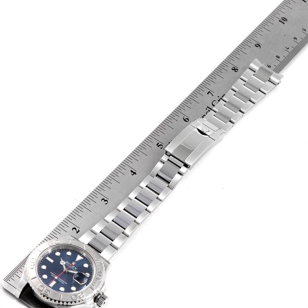 The Rolex Yacht-Master 116622 Men's Stainless Steel Blue Dial 116622 Men's Stainless Steel Blue Dial watch is shown laid out flat next to a ruler, displaying the face, bezel, and entire bracelet.