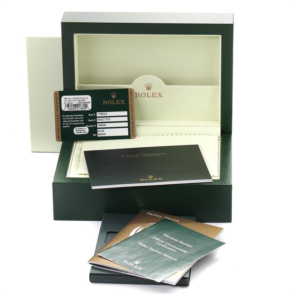 The image shows an open box of a Rolex Yacht-Master 116622 Men's Stainless Steel Blue Dial 116622 Men's Stainless Steel Blue Dial watch with warranty cards, booklets, and an instruction manual.