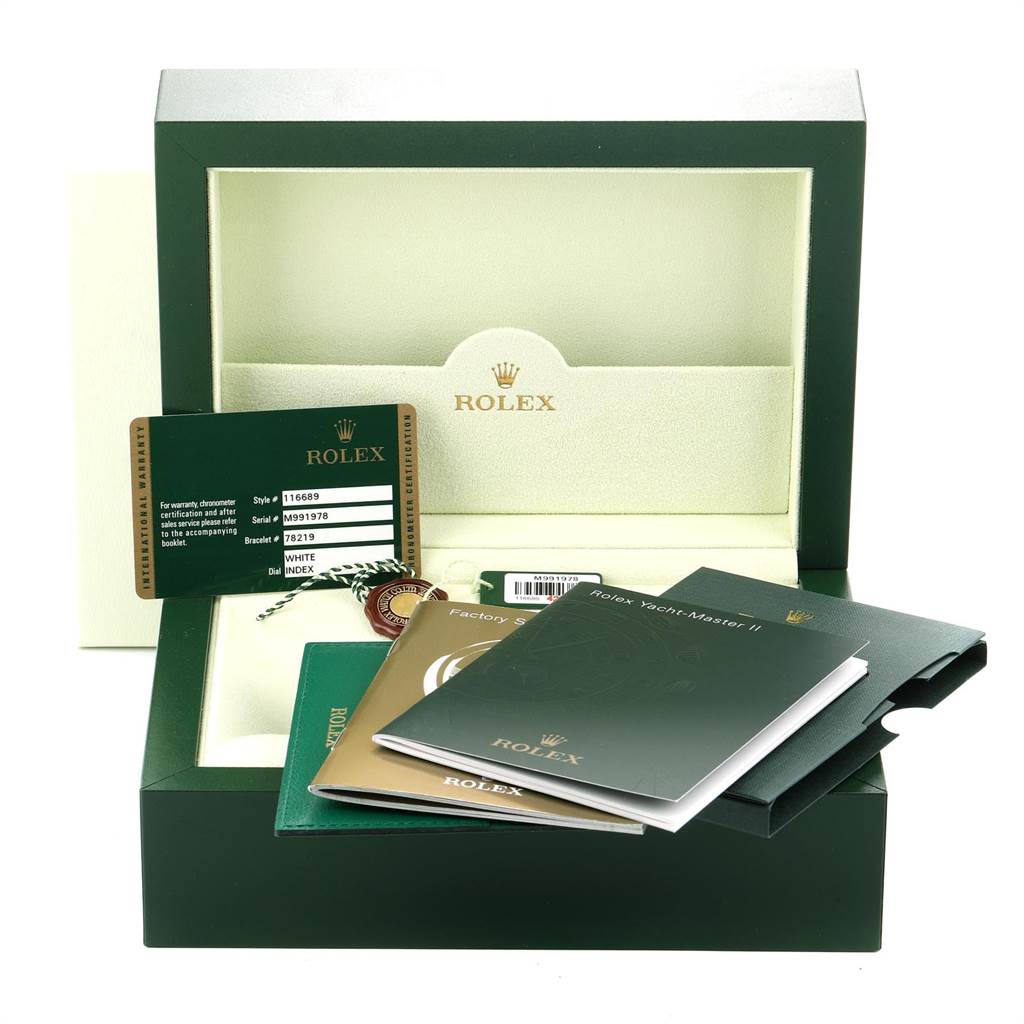 The image shows the open packaging of a Rolex Yacht-Master 116689 Men's White Gold White Dial 116689 Men's White Gold White Dial watch with accompanying booklets, tags, and a warranty card.