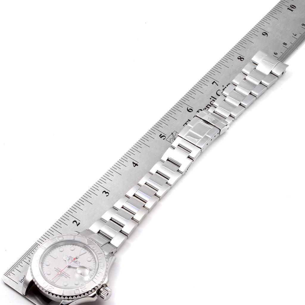 The image shows a side view of the Rolex Yacht-Master 16622 Men's Stainless Steel Silver Dial 16622 Men's Stainless Steel Silver Dial watch, focusing on the face, bracelet, and clasp, with a ruler for scale.
