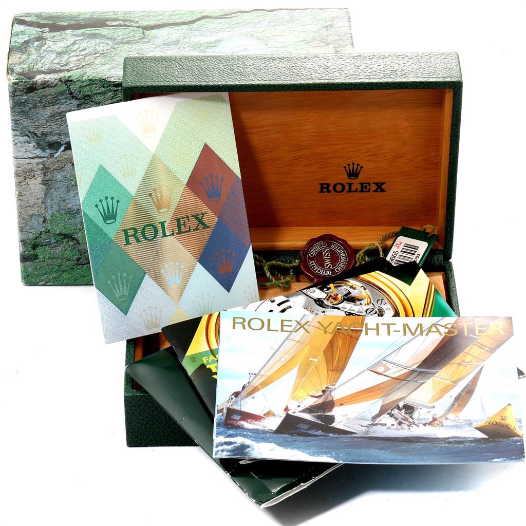 The Rolex Yacht-Master 168623 Men's Steel and Gold (two tone) Blue Dial 168623 Men's Steel and Gold (two tone) Blue Dial watch accessories shown include booklets and packaging, viewed from a front angle.