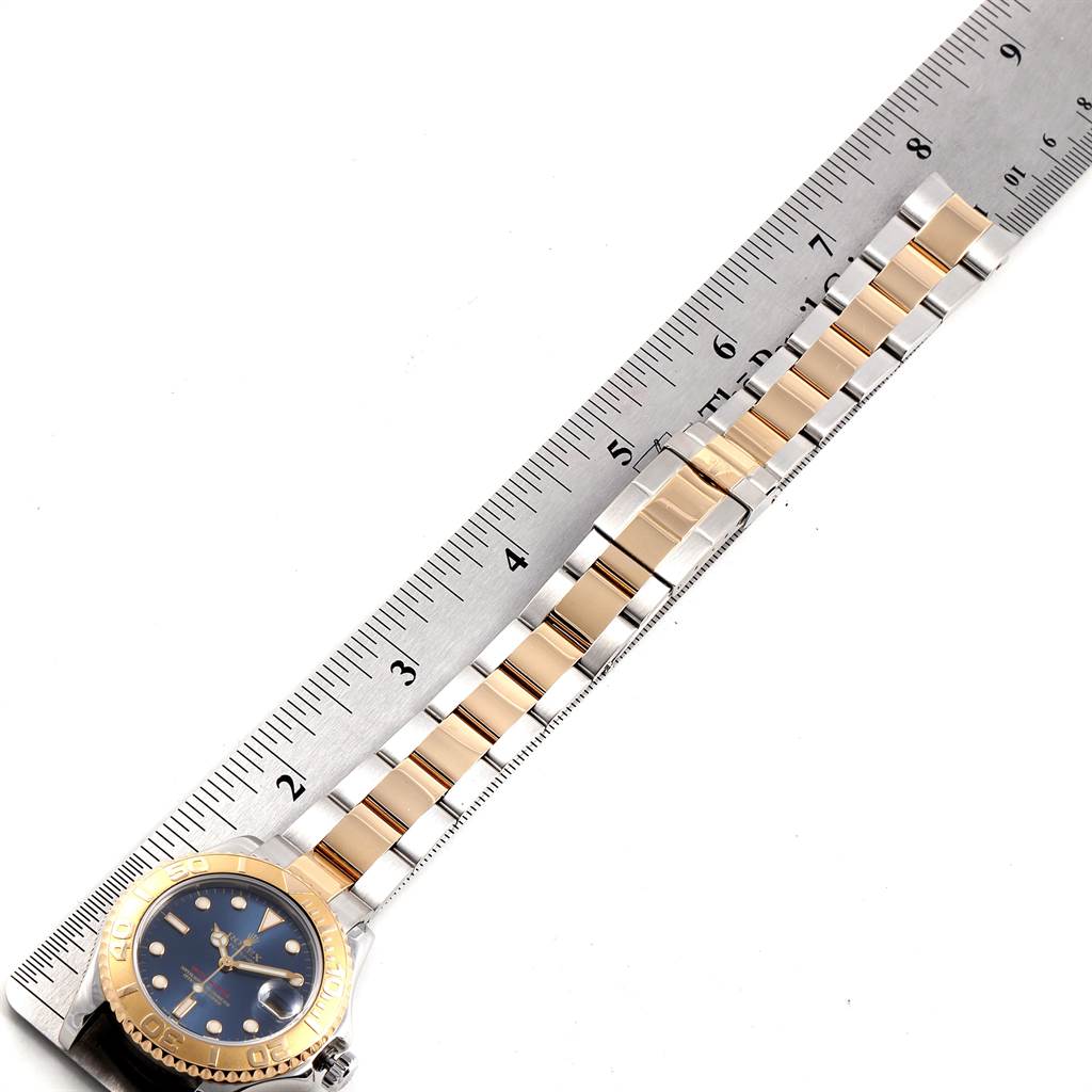The image shows the bracelet and part of the dial of a Rolex Yacht-Master 168623 Men's Steel and Gold (two tone) Blue Dial 168623 Men's Steel and Gold (two tone) Blue Dial watch, set alongside a ruler for measurement.