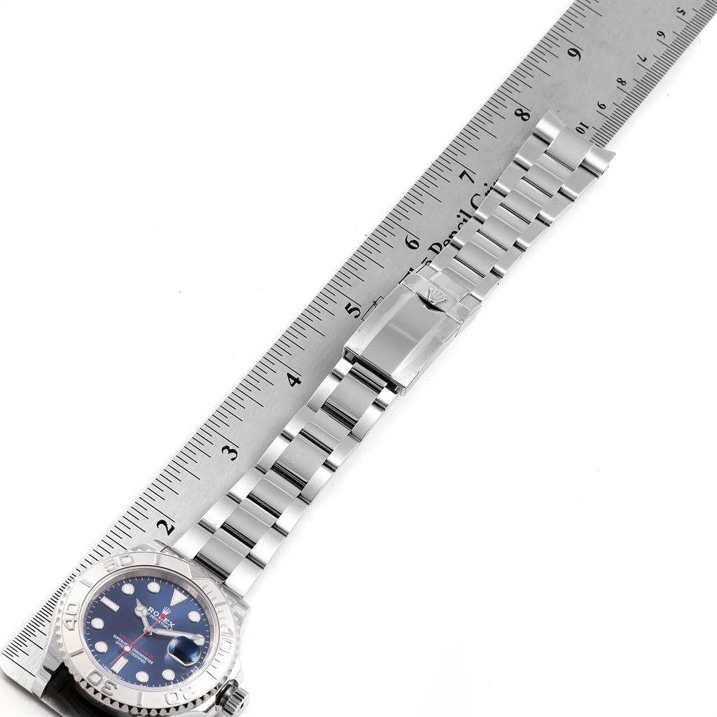 The image shows a side view of a Rolex Yacht-Master 116622 Men's Stainless Steel Blue Dial 116622 Men's Stainless Steel Blue Dial watch with its stainless steel bracelet and bezel next to a ruler for measuring length.