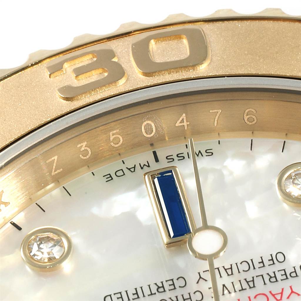 The image shows a close-up of the Rolex Yacht-Master 16628 Men
s Yellow Gold Mother of Pearl Dial 16628 Men
s Yellow Gold Mother of Pearl Dial watch, highlighting the bezel, part of the dial, and hour markers.